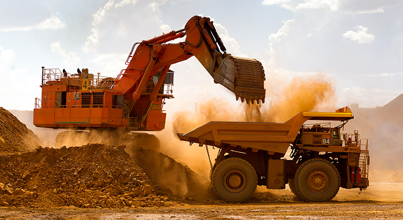 Large excatvator dumping rocks and dirt into the back of a dump truck. Large excatvator dumping rocks and dirt into the back of a dump truck.
