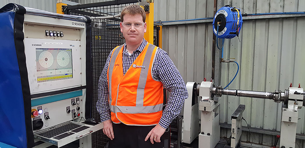Person standing in front of a heavy equipment drive-line Person standing in front of a heavy equipment drive-line