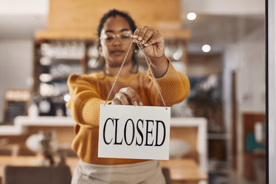 A cafe owner hanging up a closed sign