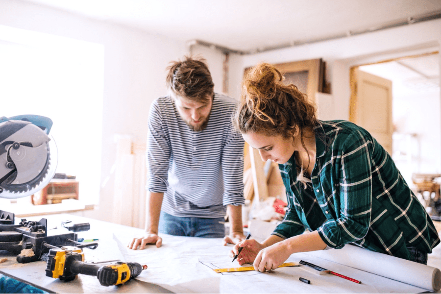 A man and woman look at plans